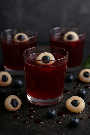 Halloween-Dessert: Blutorangen-Gelee in Gläsern mit Lychee und Heidelbeere als essbare Augen, ohne Zuckerzusatz.