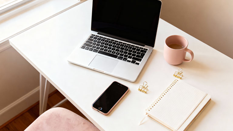 Symbolfoto eines minimalistischen Home-Office-Schreibtischs mit Laptop, Notizbuch und Kaffeetasse – steht für Pinterest-Planung und Blogging