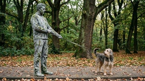 Hundehalter bleibt auf dem Gehweg stehen, weil der Hund zieht; der Hund dreht sich fragend um.