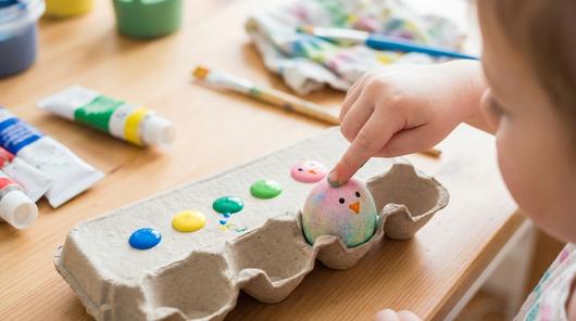 Kind macht Fingerabdruck Punkte auf Osterei, daraus entsteht ein süßes Motiv