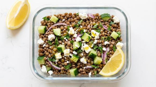 Linsensalat mit Gurke, Feta und Zwiebel in einer Meal-Prep-Box.