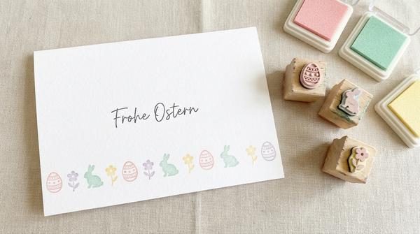 Weiße Osterkarte mit gestempelter Bordüre aus kleinen Ostermotiven und kurzem Gruß darüber.