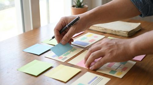 Hände sortieren Sticky Notes und Karten zur Pinterest Planung und Keyword Struktur